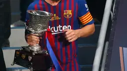 Penyerang Barcelona, Lionel Messi membawa Piala Super Spanyol usai mengalahkan Sevilla di Tangier, Maroko, (13/8). Barcelona meraih gelar ke-13 di Piala Super Spanyol terbanyak ketimbang tim lain. (AP Photo/Mosa'ab Elshamy)