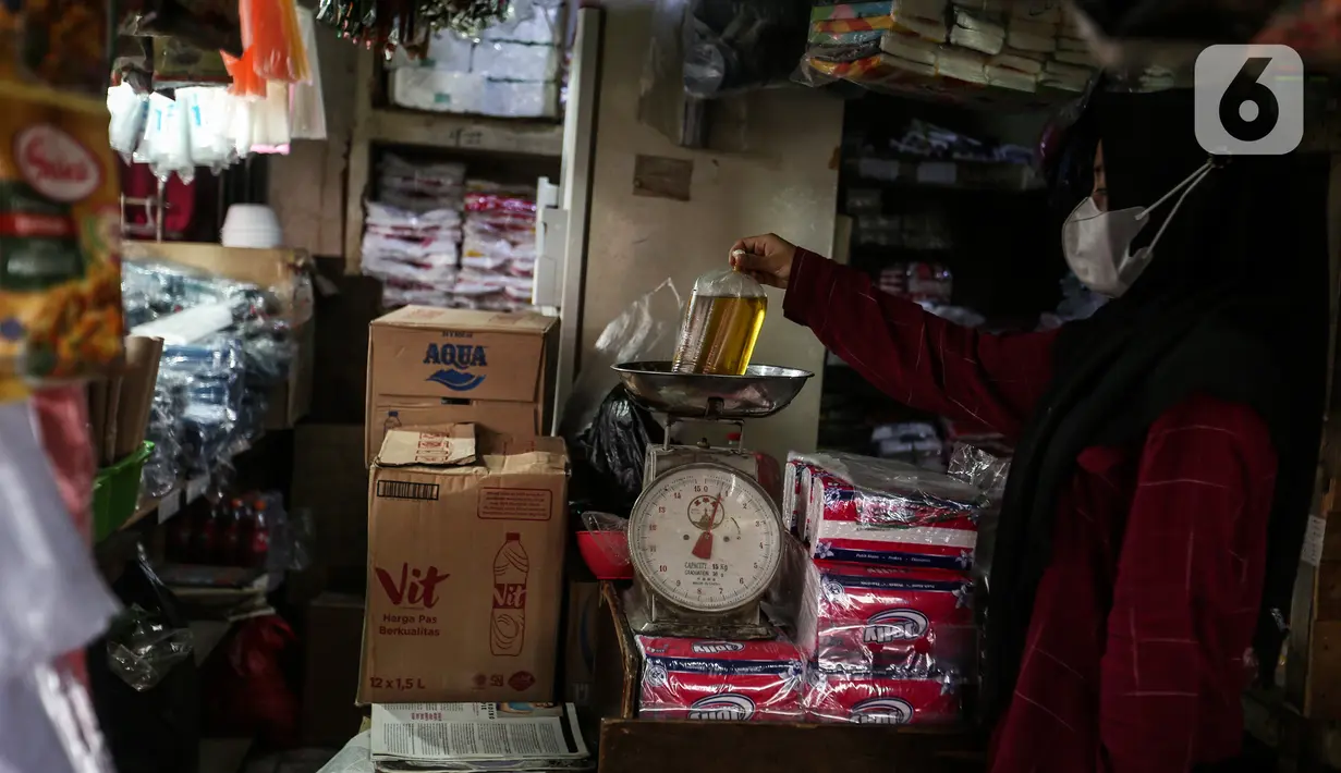 Seorang pedagang menimbang minyak goreng curah di kiosnya Pasar Kebayoran Lama, Jakarta, Rabu (19/1/2022). Pemerintah resmi mengimplementasikan kebijakan minyak goreng satu harga Rp14.000 per liter untuk semua jenis kemasan mulai hari ini. (Liputan6.com/Johan Tallo)