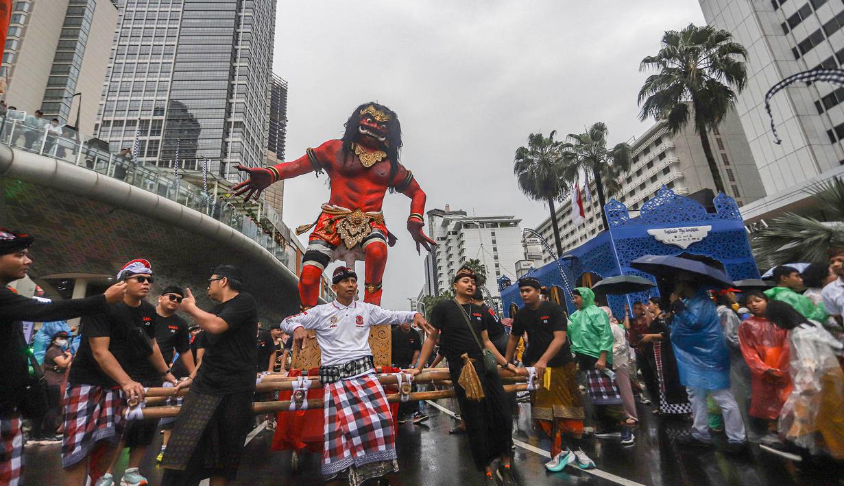Warga mengarak ogoh-ogoh saat pawai budaya di kawasan Bundaran Hotel Indonesia, Jakarta, Minggu (8/3/2026). Pemerintah Provinsi DKI Jakarta menggelar Festival Pawai Ogoh-ogoh 2026 di kawasan Bundaran Hotel Indonesia, Jakarta Pusat. (merdeka.com/Arie Basuki)