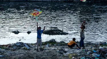 Anak laki-laki menerbangkan layang-layang di tepi sungai menjelang festival Hindu Dashain di Kathmandu (7/10/2020). Festival ini yang paling dinantikan di Nepal, Bhutan, Burma, dan perbukitan India Utara. (AFP/Prakash Mathema)