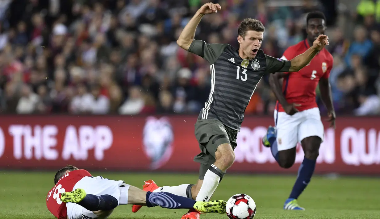 Thomas Muller (kanan) berusaha melewati hadangan pemain Norwegia, Stefan Johansen pada kualifikasi piala Dunia 2018 di Stadion Ullevaal, Oslo (5/9/2016) dini hari WIB. (AFP/ John Macdougall)