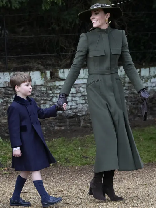 Kate Middleton, Princess of Wales dari Inggris mengandeng Pangeran Louis usai kebaktian Natal di Sandringham, Norfolk, Inggris pada 25 Desember 2022. Ia melengkapinya dengan topi bertepi lebar, juga berwarna senada, serta anting-anting chandelier dengan batu bernuansa hijau. (AP Photo/Kirsty Wigglesworth)