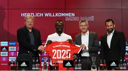 Penyerang baru Bayern Munchen, Sadio Mane (kedua kiri) dengan jerseynya berpose di samping CEO Bayern Munchen Oliver Kahn (kiri), Presiden Herbert Hainer (kedua) dan Direktur Olahraga Hasan Salihamidzic selama konferensi pers setelah ia menandatangani kontrak tiga tahun di Munich, Jerman selatan (22/6/2022). (AFP/CHRISTOF STACHE)