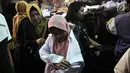 Orangtua mencoba seragam sekolah untuk anaknya di Pasar Jatinegara, Jakarta, Minggu (14/7/2019). Jelang tahun ajaran baru, Pasar Jatinegara ramai didatangi para orangtua yang mencari seragam sekolah untuk anaknya. (merdeka.com/Iqbal Nugroho)