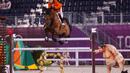 Maikel Van Der Vleuten dari Belanda mengendarai Beauville Z melewati patung pegulat sumo kecil di kualifikasi individu lompat berkuda selama Olimpiade Tokyo 2020 di Equestrian Park di Tokyo (3/8/2021). (AFP/Behrouz Mehri)
