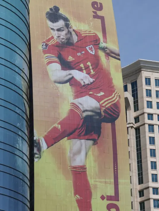 <p>Gambar besar penyerang Wales Gareth Bale dipajang di sebuah gedung jelang Piala Dunia 2022 di Doha, Qatar, Minggu (6/11/2022). Piala Dunia 2022 akan dimulai pada 20 November 2022 hingga 18 Desember dengan menampilkan pertandingan pembuka antara tuan rumah Qatar vs Ekuador pada 20 November 2022. (Giuseppe CACACE/AFP)</p>