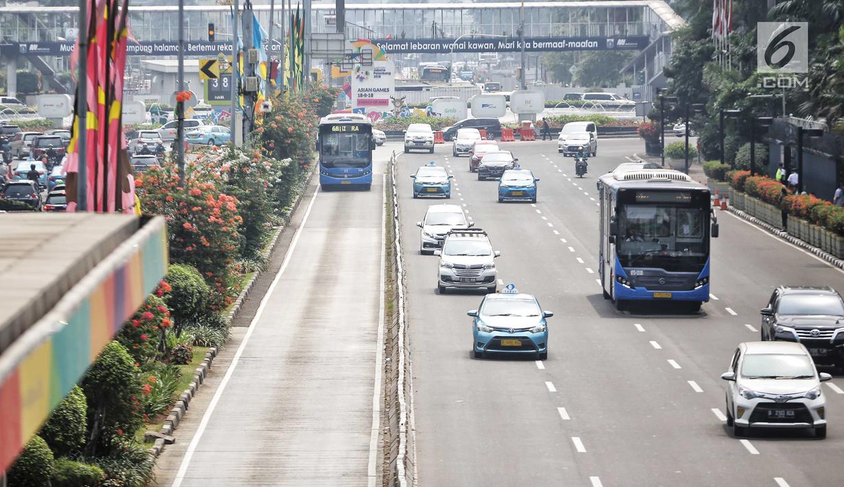 Bus Transjakarta melintas di kawasan Sudirman, Jakarta, Rabu (11/7). Pemprov DKI menyiapkan 1.500 bus Transjakarta untuk mendukung mobilitas warga, atlet, offisial, hingga jurnalis peliput pertandingan Asian Games di Jakarta. (Liputan6.com/Faizal Fanani)