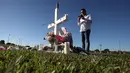 Joe Zevulon membaca kitab suci di situs peringatan untuk menghormati korban pembunuhan massal di Sekolah Marjory Stoneman Douglas, Pine Trail Park, Florida (16/2). Sebanyak 17 orang ditembak di lokasi tersebut. (Mark Wilson / Getty Images / AFP)