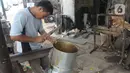 Seorang pengrajin membuat penanak nasi  di Pamulang, Tangerang Selatan, Banten  Minggu( 12/1/2020). Perabot tersebut dipasarkan hingga kawasan Jabotabek. (merdeka.com/Arie Basuki)
