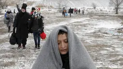 Seorang imigran terlihat lelah saat berjalan melewati hamparan salju setelah menyeberang dari perbatasan Macedonia di dekat desa Miratovac, Serbia, (18/1/2016). (REUTERS/Marko Djurica)