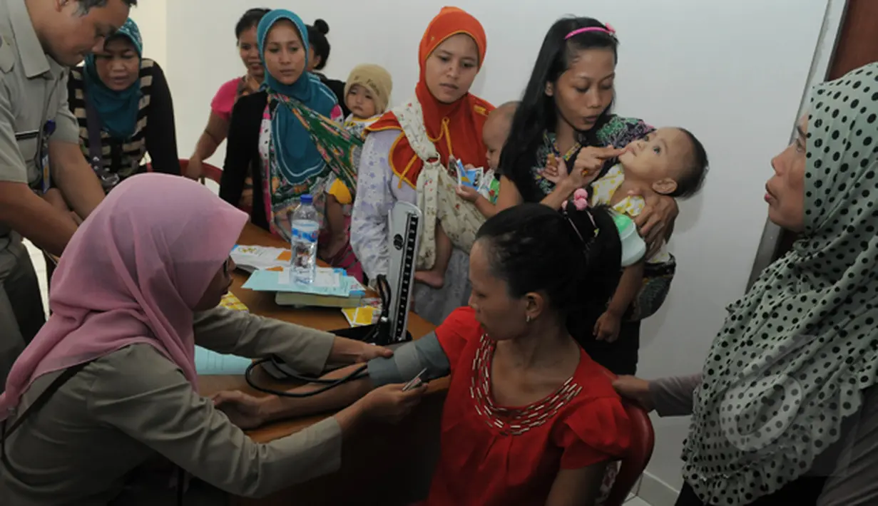 Sejumlah warga mengantri untuk mendapat pelayanan dari Puskesmas Rusunawa Tambora, Jakarta, Selasa (24/2/2015). (Liputan6.com/Herman Zakharia)