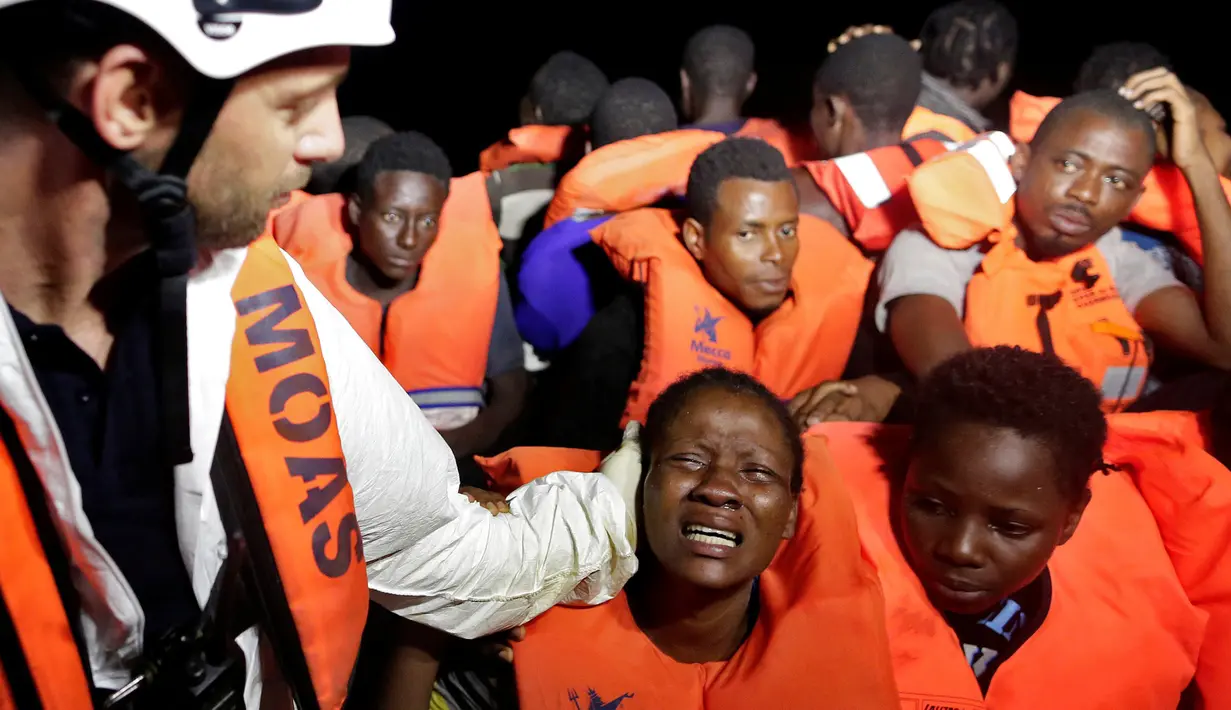 Ekspresi para imigran saat diselamatkan di laut Mediterrania, (20/10). Ribuan imigran berhasil diselamatkan dari kapal-kapal kecil di lepas pantai Libya. (Yara Nardi/Italian Red Cross press office/Handout via REUTERS)