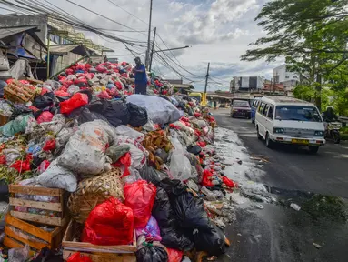 Petugas mengatur tumpukan sampah pada pinggir jalan di kawasan Pasar Manggis, Ciputat, Tangerang Selatan, Senin (15/12/2025). Sudah lebih dari sepekan wilayah Tangerang Selatan (Tangsel) mengalami krisis lokasi pembuangan akhir sampah. (merdeka.com/Arie Basuki)