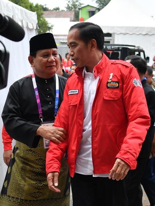 Presiden Joko Widodo atau Jokowi (kanan) dan Ketua Umum Pengurus Besar Ikatan Pencak Silat Indonesia (IPSI) Prabowo Subianto (kiri) berbincang saat akan menyaksikan pencak silat Asian Games 2018 di Jakarta, Rabu (29/8). (Liputan6.com/HO/Biro Pers Setpres)