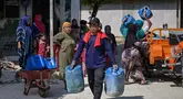 Warga membawa jeriken saat pendiistribusian air  bersih oleh Palang Merah Indonesia (PMI) Kabupaten Bangkalan di Dusun Batangan Tengah, Desa Batangan, Kecamatan Tanah Merah, Kabupaten Bangkalan, Jawa Timur, Selasa (21/7/2026). (AFP/ Juni Kriswanto)