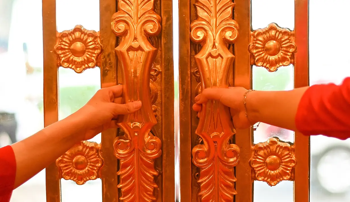 Pegawai menunggu untuk menyambut para tamu di lobi hotel Dolce Hanoi Golden Lake yang baru saja diresmikan di Hanoi, Vietnam pada Kamis (2/7/2020). Hotel tersebut merupakan hotel berlapiskan emas 24 karat pertama di dunia. (Manan VATSYAYANA / AFP)