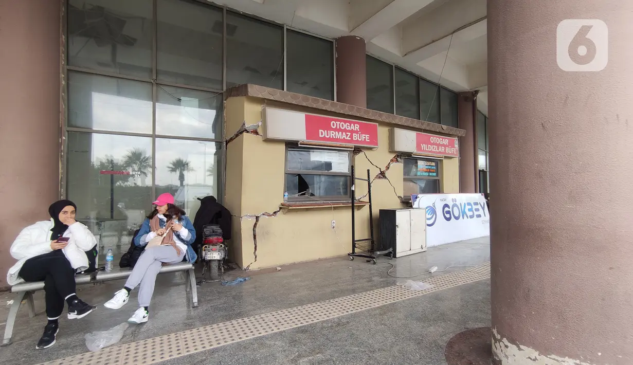 Penumpang menunggu di Antakya Terminal Otobus atau Terminal Antakya di Provinsi Hatay, Turki, Minggu (19/2/2023). Kondisi tembok gedung terminal terbelah dengan atap-atap yang roboh digoyang gempa. (Liputan6.com/Andre Haryanto)