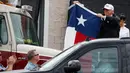 Presiden AS, Donald Trump mengibarkan bendera Texas di hadapan warga yang bersorak padanya di Firehouse 5 in Corpus Christi, Selasa (29/8). Trump mencoba menyemangati warganya lewat kunjungan ke Texas yang dihantam badai Harvey. (AP Photo/Evan Vucci)