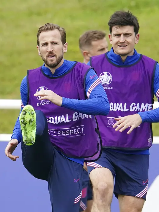 Penyerang Inggris, Harry Kane dan bek Harry Maguire melakukan pemanasan selama sesi latihan di St George's Park, Burton upon Trent, Inggris, Sabtu (10/7/2021).  Inggris akan bertanding melawan Italia pada final Euro 2020 di Stadion Wembley. (AP Photo/Dave Thompson)
