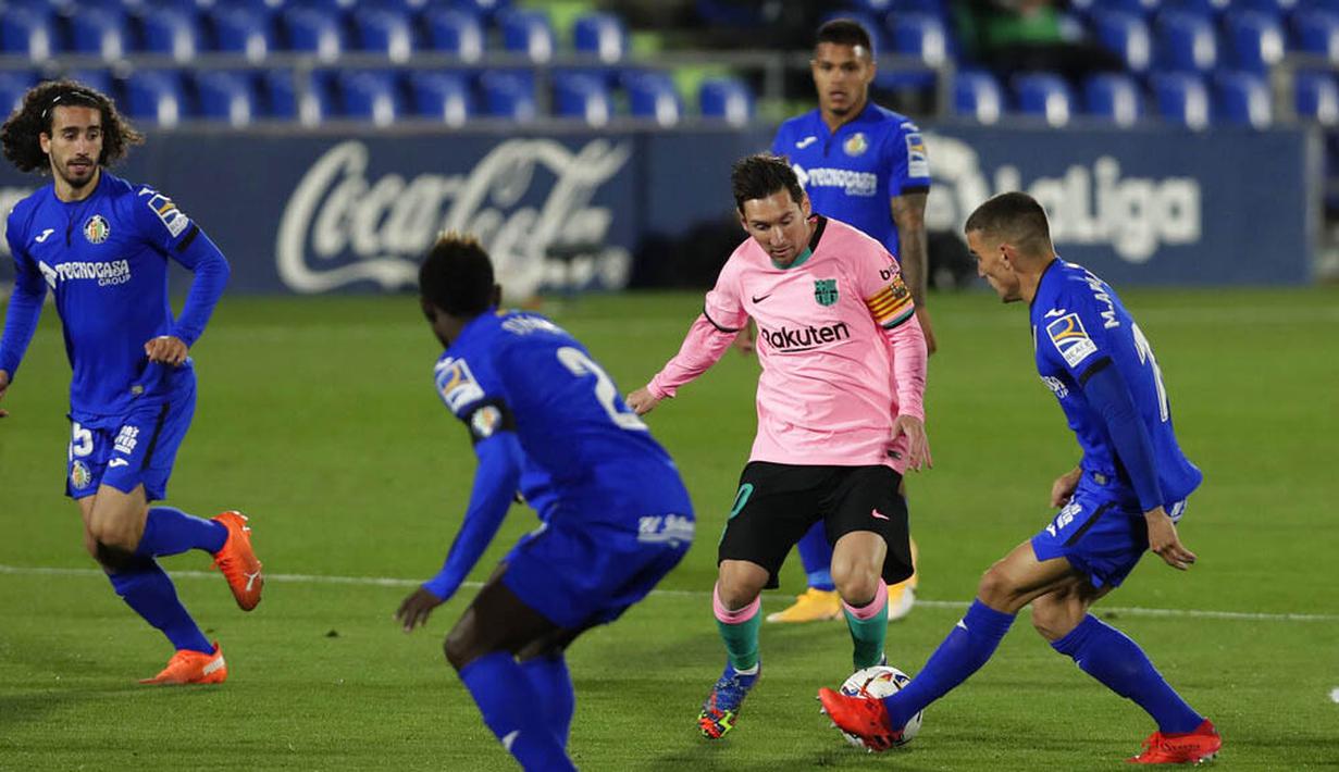 Striker Barcelona, Lionel Messi, berusaha melewati pemain Getafe pada laga Liga Spanyol di Stadion Coliseum Alfonso Perez, Minggu (18/10/2020). Barcelona takluk dengan skor 1-0. (AP/Manu Fernandez)