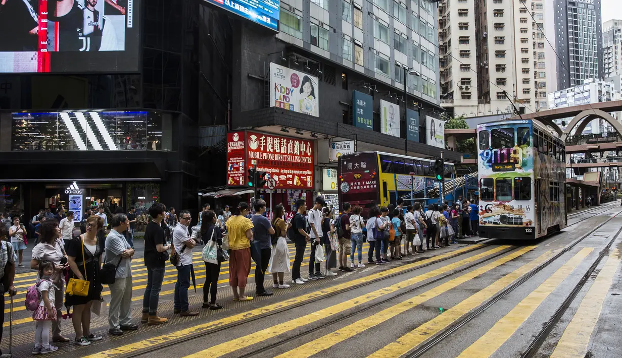 Warga menunggu Commuter di halte trem setelah beberapa layanan Mass Transit Railway (MTR) dilumpuhkan oleh pengunjuk rasa yang menentang RUU ekstradisi yang kontroversial di Hong Kong (30/7/2019). (AFP Photo/Isaac Lawrence)