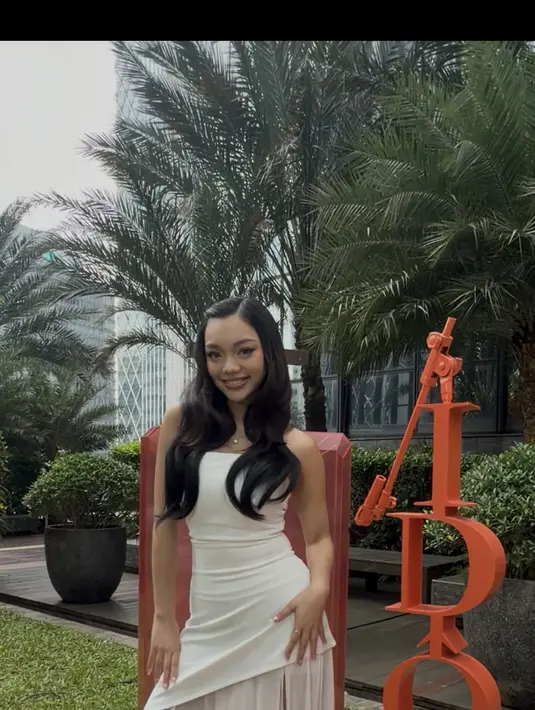 Naura Ayu tampil cantik dengan strapless asymetric top dan rok slit yang flowy. Tampilannya terlihat dreamy dengan open toe heels dari Dior.