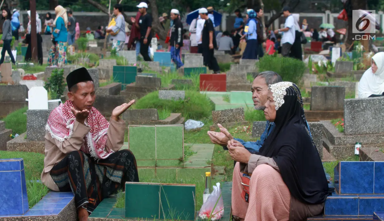 Warga berdoa saat berziarah di TPU Karet Pasar Baru Barat, Jakarta, Sabtu (16/6). Ziarah kubur atau "nyekar" pada hari raya lebaran merupakan salah satu tradisi umat muslim untuk mendoakan sanak keluarga yang meninggal dunia. (Liputan6.com/Arya Manggala)