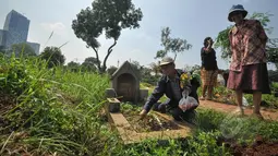 Umat Kristiani melakukan ziarah ke makam keluarga dan kerabatnya pada momen Paskah di TPU Menteng Pulo, Jakarta, Minggu (5/4/2015). (Liputan6.com/Faizal Fanani)