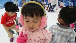 Ekspresi seorang anak saat bermain dengan sajlu dan es di Snow Village pada salah satu pusat perbelanjaan di kawasan Tangerang Selatan, Banten, Senin (17/12). (Merdeka.com/Arie Basuki)