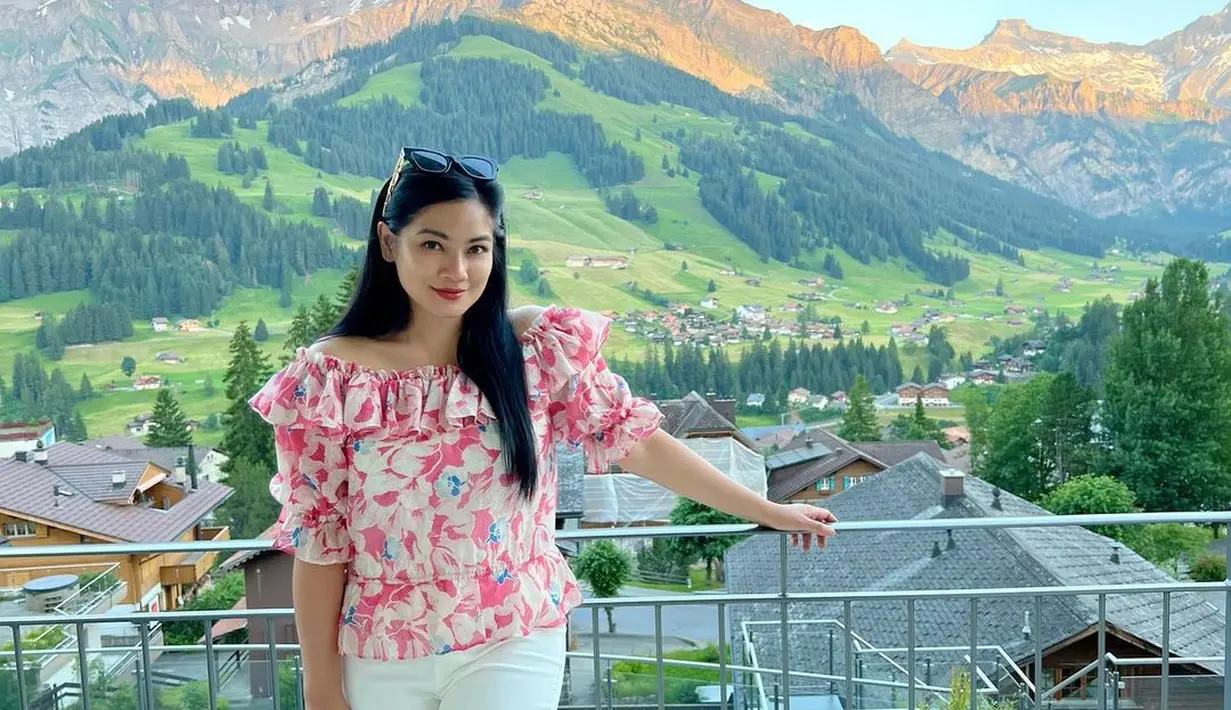 Blouse motif bunga dan celana putih, outfit Titi Kamal saat di Switzerland. (sumber : Instagram @titi_kamall)