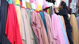 Pedagang merapikan bahan kain yang akan dijual di kawasan Tangerang, Banten, Sabtu (25/9/2021). Program Restrukturisasi Mesin/Peralatan tahun 2021 bertujuan meningkatkan kembali performa industri Tekstil dan Produk Tekstil (TPT) sebagai sektor strategis. (Liputan6.com/Angga Yuniar)