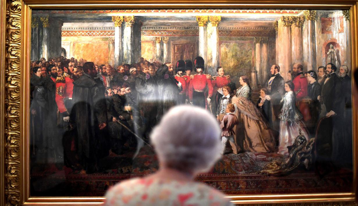 Ratu Inggris Elizabeth II melihat lukisan Ratu Victoria yang sedang memeriksa Penjaga Coldstream tahun 1855 karya John Gilbert sebagai bagian dari pameran di Istana Buckingham, London, Rabu (17/7/2019). Pameran tersebut menandai peringatan 200 tahun kelahiran Ratu Victoria. (AP Photo/Frank Augstein)