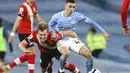 Pemain Manchester City, Phil Foden, berebut bola dengan pemain Southampton, James Ward-Prowse, pada laga Liga Inggris di Stadion Etihad, Kamis (11/3/2021). City menang dengan skor 5-2. (Clive Brunskill/Pool via AP)