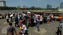 Warga antre untuk menaiki kereta wisata ketika berwisata di Monumen Nasional atau Monas, Jakarta, Minggu (19/7/2015). Ikon kota Jakarta tersebut menjadi tempat wisata alternatif warga saat liburan lebaran. (Liputan6.com/Johan Tallo)