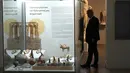 Seorang petugas keamanan presiden berdiri di belakang barang antik yang dipulangkan dari Jerman dan dipajang di museum Arkeologi, di ibu kota Nicosia, Siprus, Senin (22/7/2024). (AP Photo/Petros Karadjias)