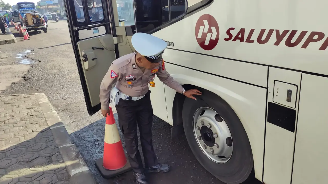 Salah seorang petugas lantas polres Garut tengah melakukan ramp check kendaraan bis AKAP menjelang libur panjang isra mikraj dan imlek di Terminal Bis Tipe A Guntur Melati, Garut. (Liputan6.com/Jayadi Supriadin)