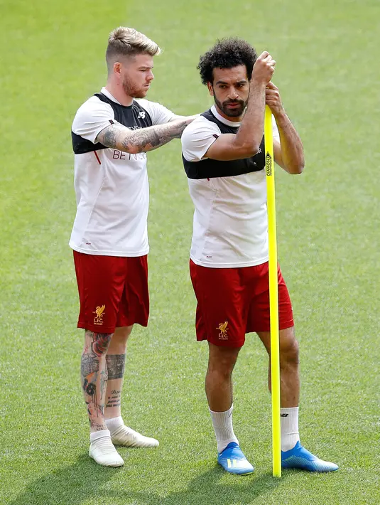 Gelandang Liverpool, Mohamed Salah  berbincang dengan Alberto Moreno saat latihan tim di stadion Anfield, Inggris (21/5). Pemain 25 tahun asal Mesir ini merupakan pencetak gol terbanyak tim pada musim ini. (AP Photo/Martin Rickett)