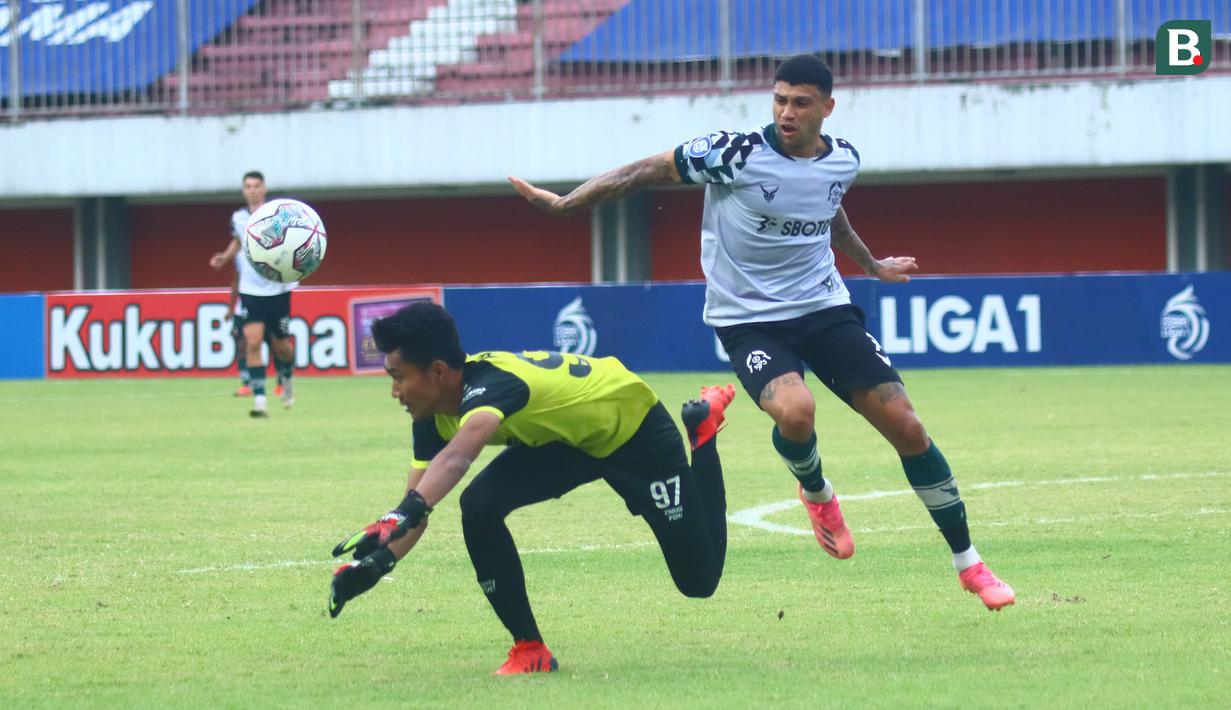 Kiper PSM Makassar, Hilman Syah (kiri) mencoba mengamankan bola dari ancaman pemain Persikabo 1973, Ciro Alves dalam laga pekan ke-9 BRI Liga 1 2021/2022 di Stadion Maguwoharjo, Sleman, Selasa (26/10/2021). (Bola.com/Nandang Permana)
