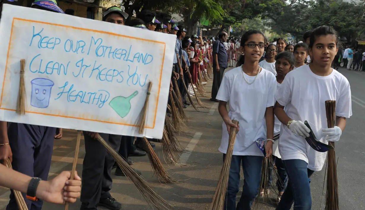 Sejumlah pelajar India membawa sapu saat mengambil bagian dalam 'Swachh Bharat Abhiyan' atau kampanye kebersihan di Hyderabad (12/2). Kampanye ini bertujuan untuk membersihkan jalanan dan infrastruktur di kota-kota India. (AFP Photo/Noah Seelam)