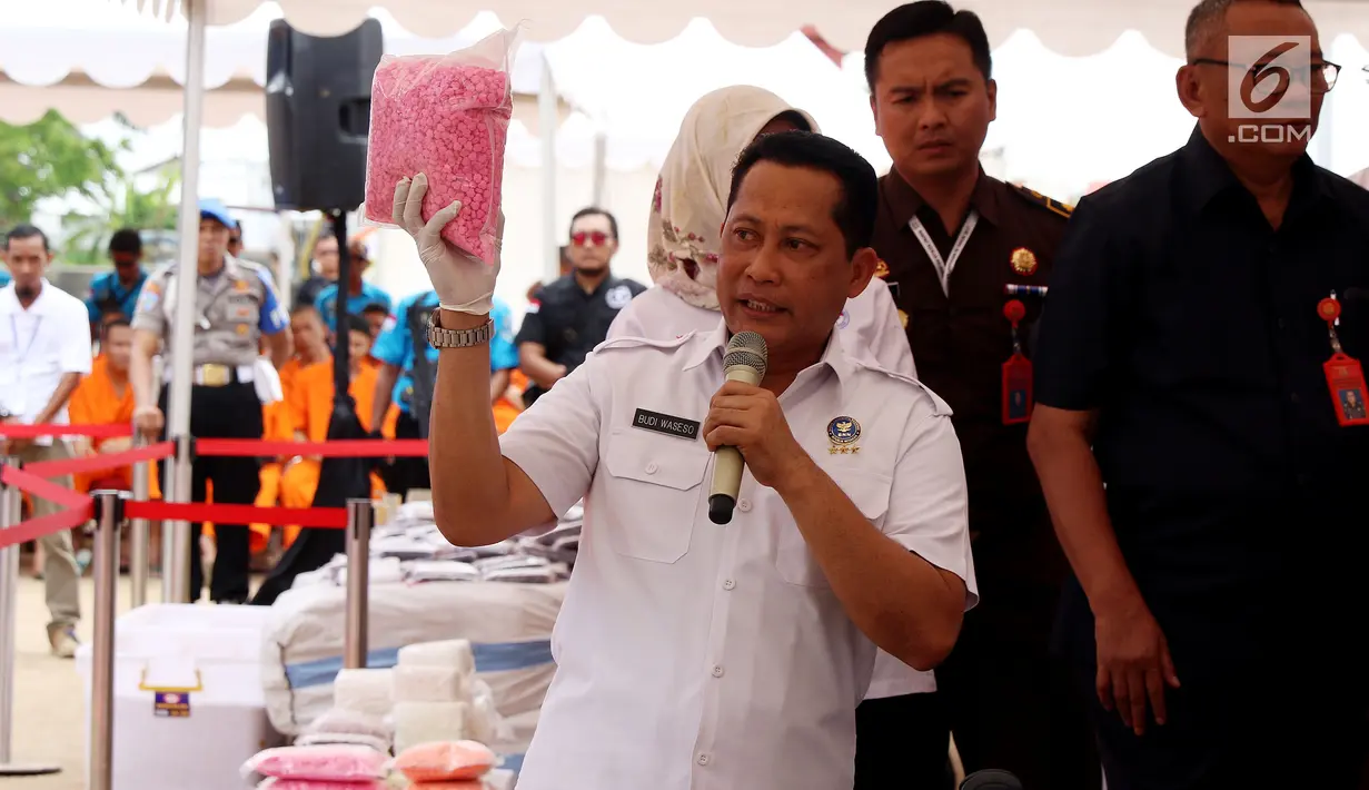 Kepala BNN Budi Waseso memberi keterangan sambil menunjukkan barang bukti narkotika saat pemusnahan di Bandara Soekarno Hatta, Banten, Kamis (28/12). Barang bukti yang dimusnahkan yaitu 453,56 kg shabu, 712,116 butir ekstasi. (Liputan6.com/JohanTallo)