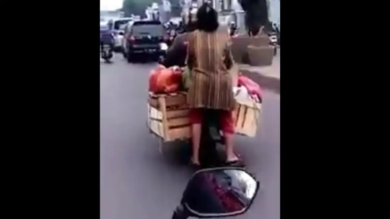 Emak-Emak duduk di motor.