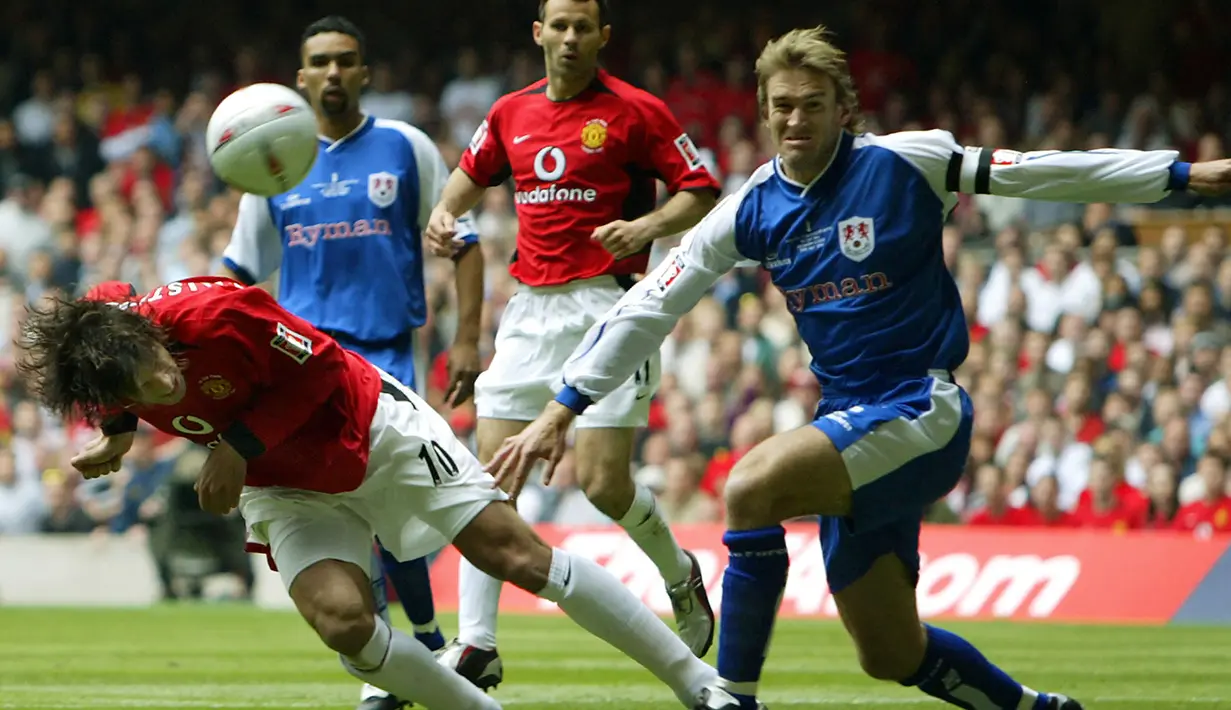 Striker Manchester United, Ruud van Nistelrooy (kiri) melepaskan sundulan ke gawang Millwall pada laga final Piala FA 2003/2004 di Millennium Dome, Cardiff, Wales (22/5/2004). Manchester United menjuarai Piala FA 2003/2004 setelah mengalahkan Millwall 3-0 lewat gol-gol dari Cristiano Ronaldo dan brace Ruud van Nistelrooy. (AFP/Adrian Dennis)