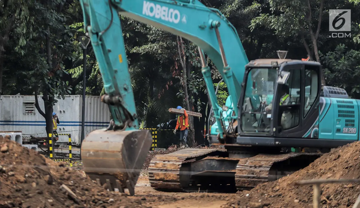 Pekerja menyelesaikan proyek pembangunan mass rapid transit (MRT) fase II rute Bundaran HI-Kota di Taman Monumen Nasional (Monas), Jakarta, Selasa (2/7/2019). MRT fase II mencakup Stasiun Sarinah, Monas, Harmoni, Glodok, Sawah Besar, Mangga Besar, dan Kota. (Liputan6.com/Faizal Fanani)