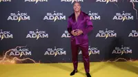 Dwayne Johnson berpose untuk fotografer saat tiba pada pemutaran perdana film 'Black Adam' di London, Inggris, 18 Oktober 2022. Dwayne Johnson memamerkan tubuh kekar bertatonya dengan tidak memakai pakaian di dalam tuksedo yang dia kenakan. (Photo by Vianney Le Caer/Invision/AP)