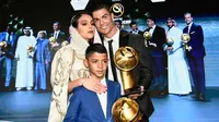 Striker Juventus, Cristiano Ronaldo bersama kekasihnya Georgina Rodriguez dan putranya Cristiano Jr berpose dengan trofi Pemain Terbaik Tahun 2018 selama Dubai Globe Soccer Awards ke-10 di Dubai (3/1). (AFP Photo/Fabio Ferrari)