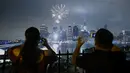 Warga mengambil gambar kembang api yang menghiasi langit kota New York saat perayaan hari kemerdekaan Amerika Serikat (AS) , Senin (4/7). AS merayakan hari ulang tahun kemerdekaan yang ke-240 dari Inggris. (KENA Betancur/AFP)