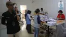 Untuk mengantisipasi surat suara hilang atau indikasi perbuatan curang, pegawai KPU Jakarta melakukan penjagaan serta pemeriksaan para pekerja, baik sebelum maupun sesudah melakukan penyortiran dan pelipatan surat suara. (Liputan6.com/Angga Yuniar)