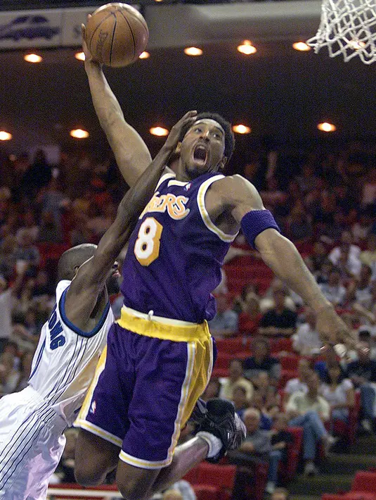Pemain Los Angeles Lakers, Kobe Bryant berusaha memasukan bola dari kawalan pemain Orlando Magic Darrell Armstrong  selama pertandingan NBA di Arena di Orlando, FL pada 21 Maret 1999. (AFP Photo/Tony Ranze)