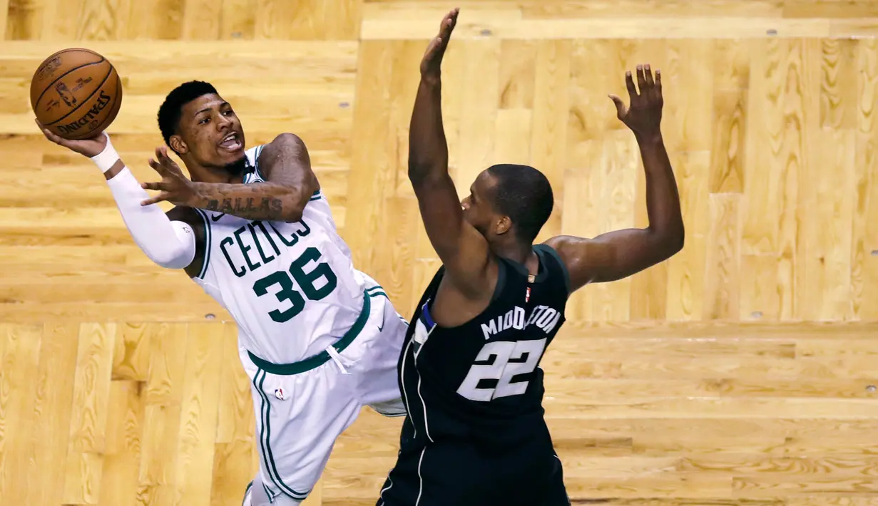 Pemain Boston Celtics, Marcus Smart (36) berusaha memasukan bola saat diadang pemain Milwaukee Bucks, Khris Middleton (22) pada laga playoffs NBA basketball di TD Garden, Boston, (24/4/2018). Celtics menang  92-87. (AP/Charles Krupa)