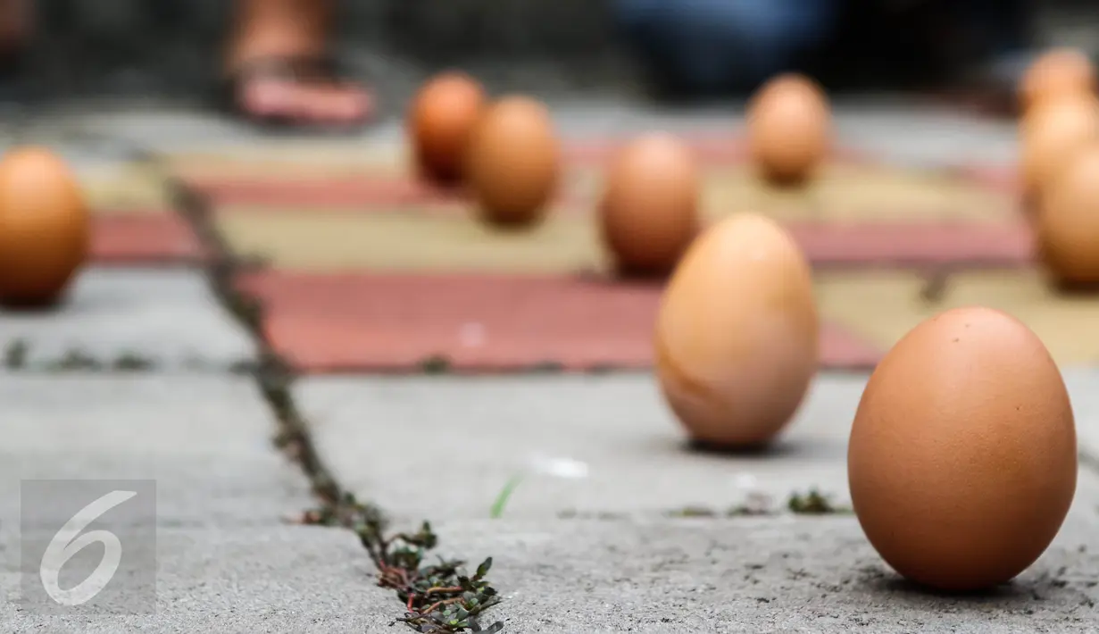 Warga etnis Tionghoa mencoba mendirikan telur ayam pada dalam perayaan Peh Cun di Pasar Lama, Kota Tangerang, Kamis (9/6).  Fenomena ini hanya terjadi satu tahun sekali yakni pada tanggal 5 bulan 5 penanggalan Imlek. (Liputan6.com/Fery Pradolo)